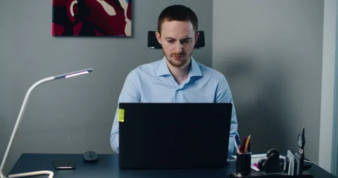 Man sitting in office and working on laptop. Businessman looking at computer Stock Footage 148132556