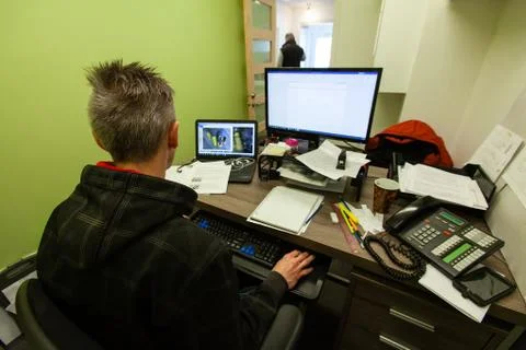 Man sitting at office desk with computer Stock Photos