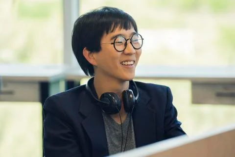 Man sitting in office, smiling cheerfully Stock Photos