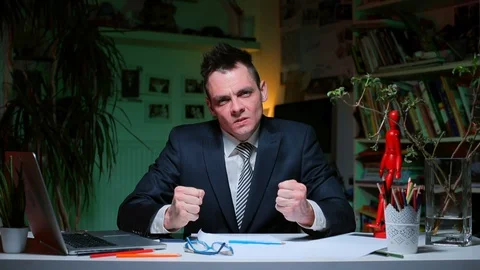 A man sitting at an office table demonstrates emotional processes. Stock Footage 128028418