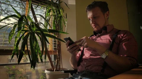 The man sitting in the office using a smartphone Stock Footage 49339472