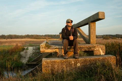 A man sitting on an old bridge Stock Photos