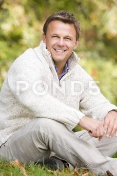 Man sitting outdoors smiling (selective focus) Stock-Fotos