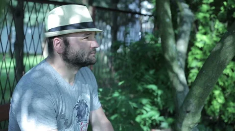 Man sitting outside contamplatting, young woman comes in and sits, then both  Video stock 59143757