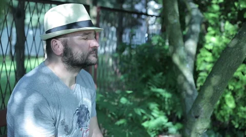 Man sitting outside contamplatting, young woman comes in and sits, then both  Video stock 59145130