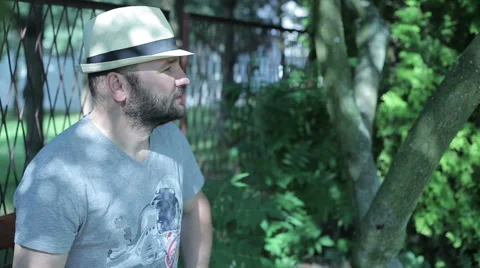 Man sitting outside contemplating then looking into camera and smile Stock Footage 59143144