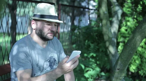 Man sitting outside, picking up the phone and talking Stock Footage 59144154