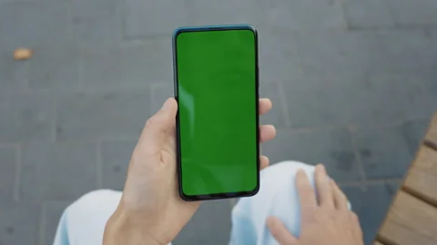 Man Sitting Outside Using Phone With Green Mock-up Screen Chroma Key Surfing Stock Footage 237109698