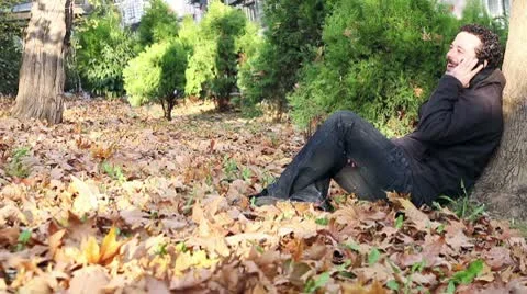 Man sitting in the park and talking on cellphone Stock-Footage 9874717