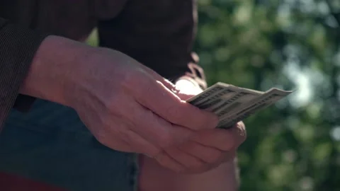 Man is sitting on park bench and counting money. selective focus. slow motion. Stock Footage 219635691