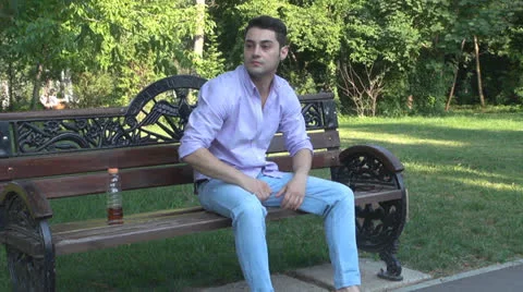 Man sitting on park bench, bored, nervous Video stock 25560956