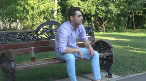 Man sitting on park bench, bored, nervous Vídeos de archivo 25562099