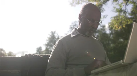 A man sitting in a park using a laptop, Sweden. 스톡 동영상 51852319