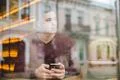 The man sitting with a phone over the window in a cafe Photo