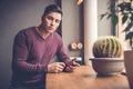 The man sitting with a phone in the restaurant Photo