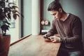 The man sitting with a phone in the restaurant Photo