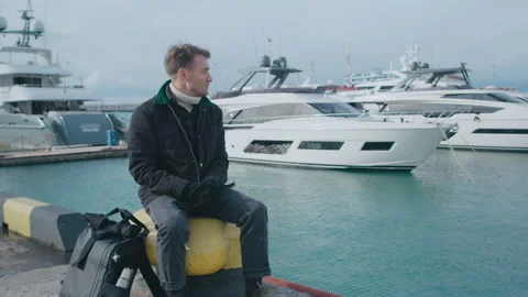 Man sitting on the pier and taking a rest Stock Footage 151077474