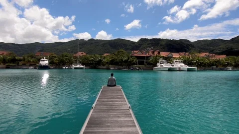 The man is sitting on the pier. Stock Footage 101976531