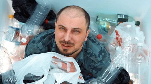 Man sitting in a pile of plastic Stock Footage 125329415