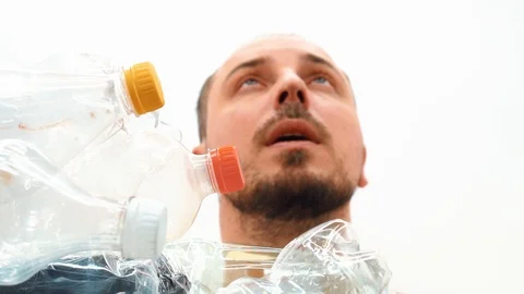 Man sitting in a pile of plastic Stock Footage 125329442