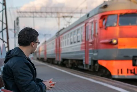 A man sitting on the platform against the background of locomotive Stock Photos