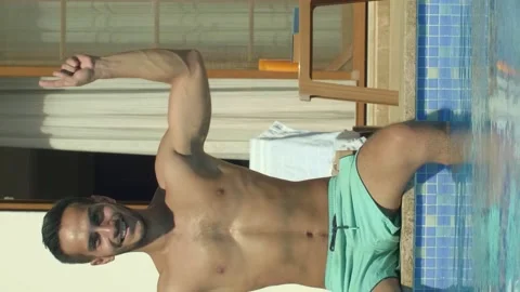 Man sitting by the pool points to the top of the screen with two fingers. Stock Footage 143958105