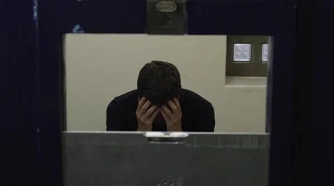 Man sitting in prison cell. Stock Footage 61041360