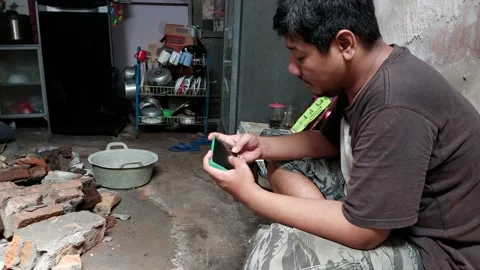 A man is sitting relaxed while playing a game on his cellphone Stock Footage 233645079