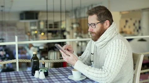 Man sitting in the restaurant and browsing internet on smartphone Video stock 58188198