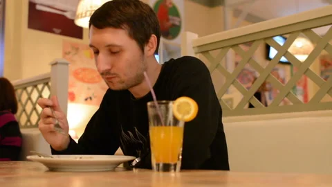 A man sitting in a restaurant and eats salad Stock Footage 89010015