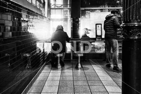 Man sitting in a restaurant in new york. Black and white version. Stock Photos