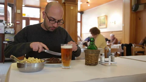 Man Sitting At Restaurant Table With Beer And Meal Vídeo Stock 344852709
