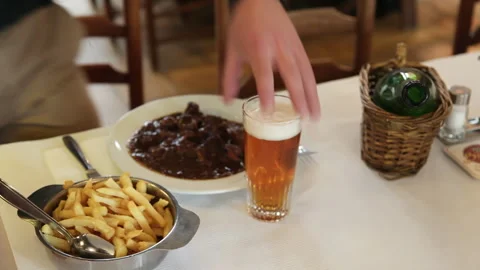 Man Sitting at Restaurant Table Enjoying Lunch with Beer 库存影片 343367023