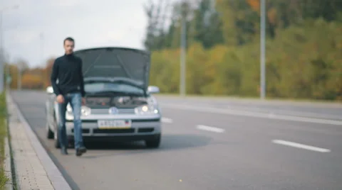 Man sitting on the road in a front of broken car 스톡 동영상 68412066