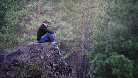 Man sitting on Rock in Forest Stock Footage 95953277