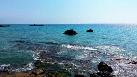 Man Sitting On Rocks Looking At Turquoise Sea At Sunny Beach Stock Footage 333598150