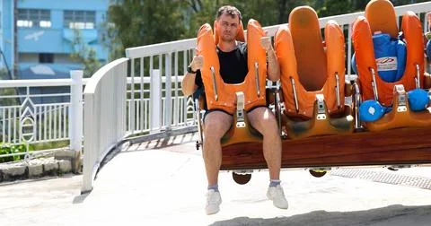 Man Sitting on Roller Coaster Giving Thumbs Up at Amusement Park Stock Photos