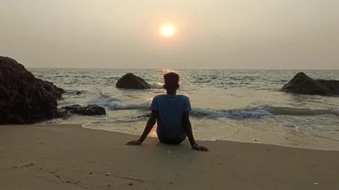 Man Sitting on Sandy Beach Watching Sunset, Vengurla, India Stock Footage 314182124