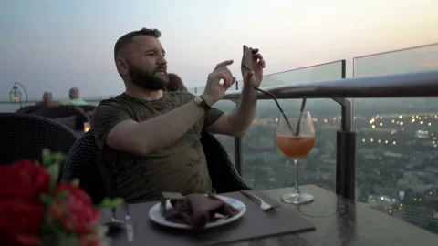 Man sitting in skybar and doing photos of the view  Stock Footage 88538087