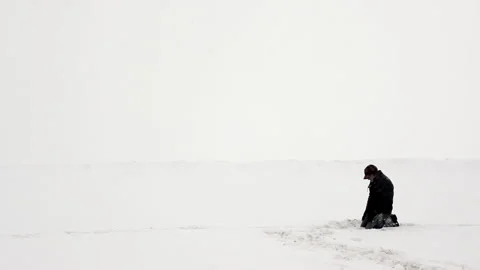 Man sitting on the snow during a storm Stock Footage 162256948