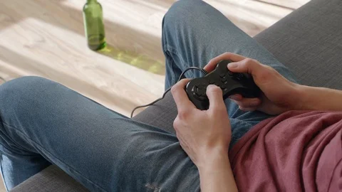 The man sitting on the sofa and play in video game Stock Footage 105939840