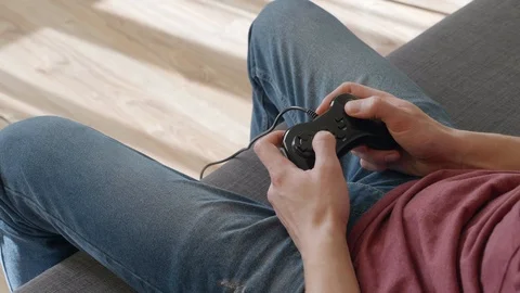 The man sitting on the sofa and play in video game Stock Footage 105939868