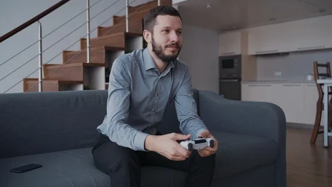 Man is sitting on sofa and playing in video game very emotional way. Stock Footage 107074808