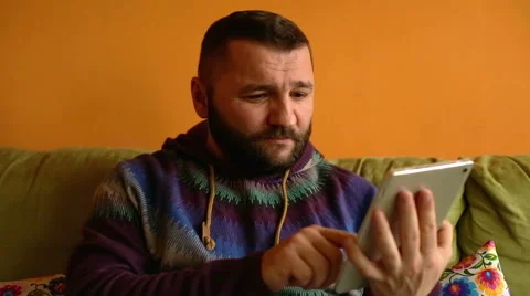 Man sitting on sofa and usin tablet  Stock Footage 61303488