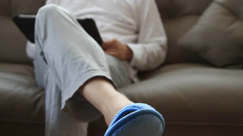 Man sitting on sofa and using tablet pc Stock Footage 37244140