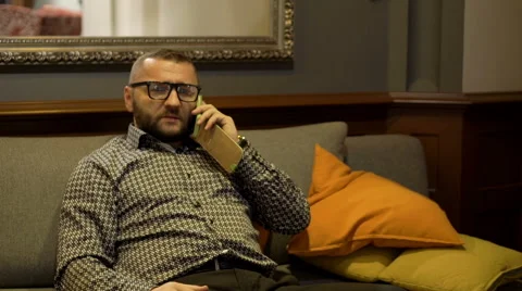 Man sitting on sofa and using phone  Video stock 60662749