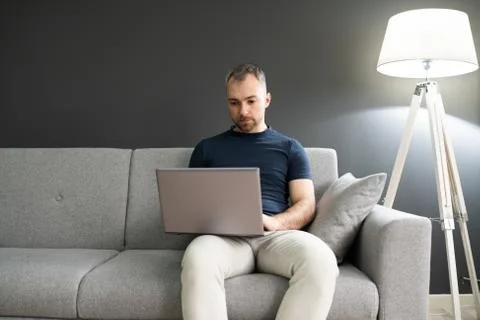 Man Sitting In Sofa And Using Laptop Stock Photos