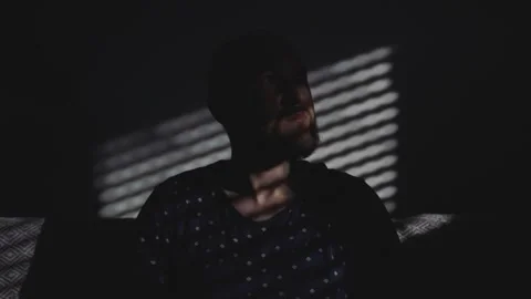 Man sitting on a sofa in a dark room. Stock Footage 274951520