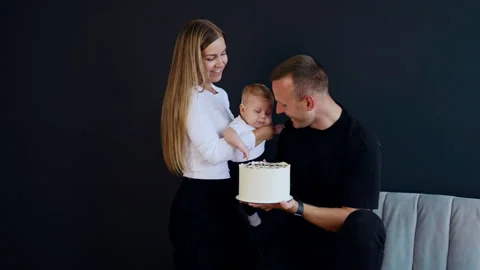 Man sitting on the sofa holding a white cake.  Stock Footage 253602876