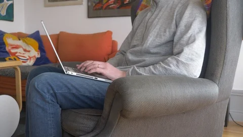 Man sitting in sofa with laptop working from home Stock Footage 127650034